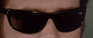 a close up of a person wearing sunglasses with the letter f on the lens