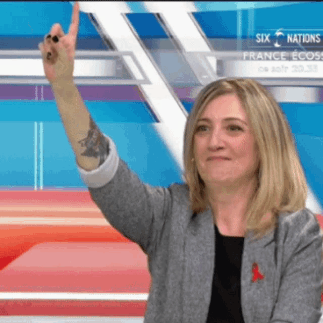 a woman giving a thumbs up in front of a six nations logo