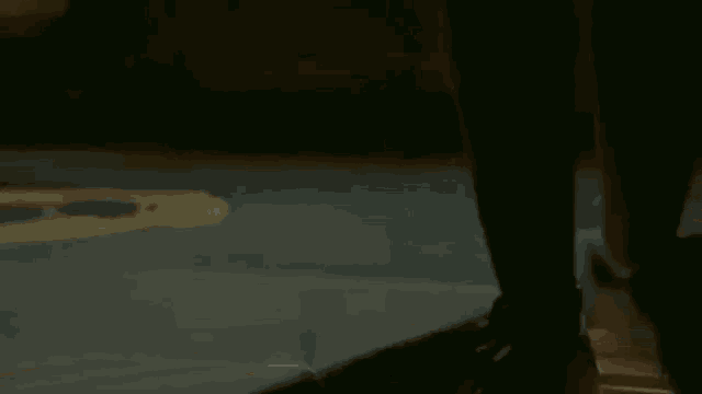 a person is sitting in a car looking out the window at a basketball court at night .