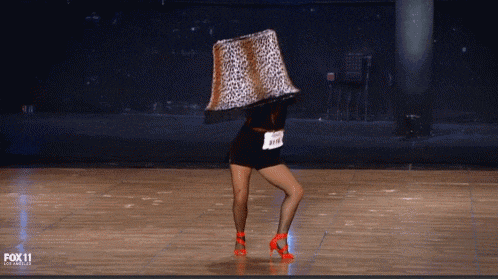 a woman is dancing with a lamp on her head and the fox 11 logo can be seen behind her