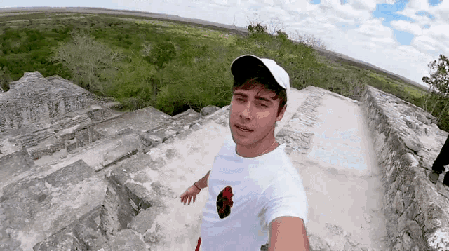 a young man wearing a white hat and a white shirt takes a selfie