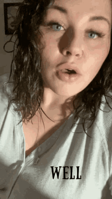 a woman wearing a white shirt with well written on it