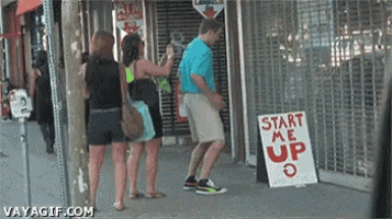 a man stands in front of a sign that says " start me up "