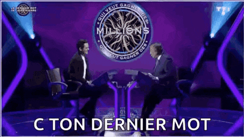 two men are sitting in chairs on a stage talking to each other on a television show .