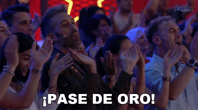 a group of people applauding with the word pase de oro in the corner