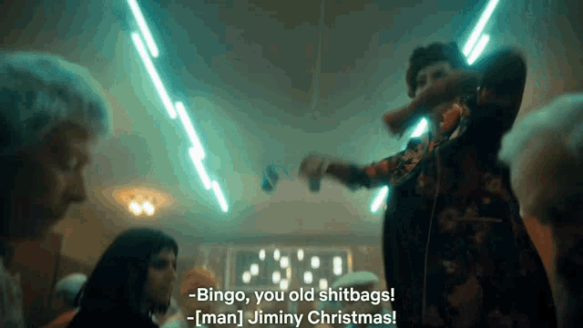 a group of people are dancing in a dark room and a man says " bingo you old shitbags "