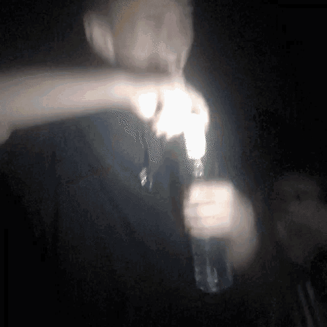 a blurry picture of a man holding a bottle of water