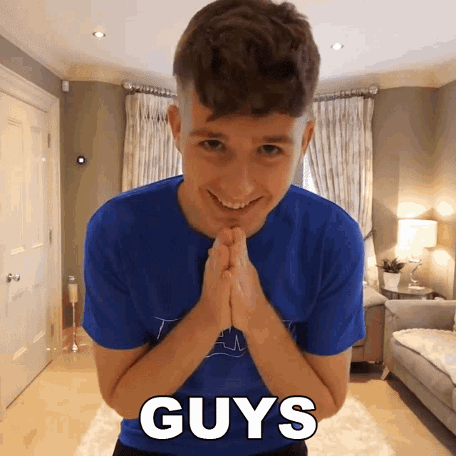 a man wearing a blue shirt with the word guys on the front