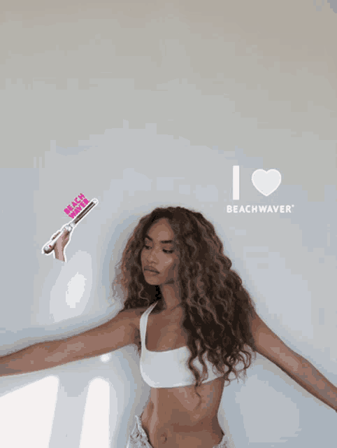 a woman with wavy hair is holding a beach waver