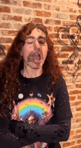 a woman wearing a shirt with a rainbow on it