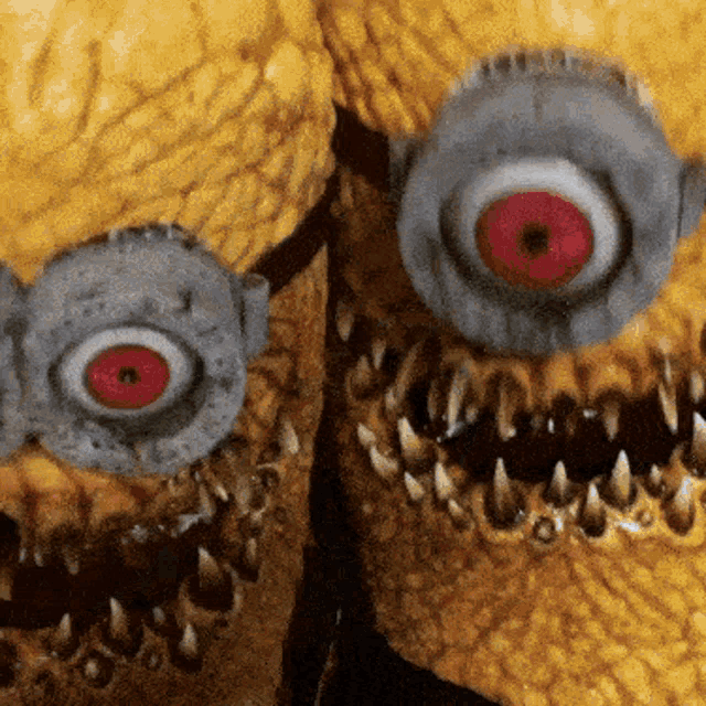 a close up of a stuffed animal with a red eye and sharp teeth