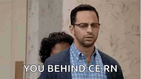 a man with glasses is standing next to another man with a beard and says `` you behind cern '' .
