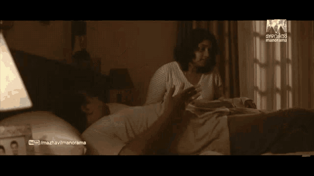a man with a mustache is laying on a bed with a manorama logo on the corner