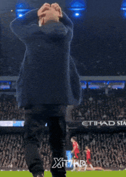 a man in a suit is dancing in front of a sign that says xit7hd