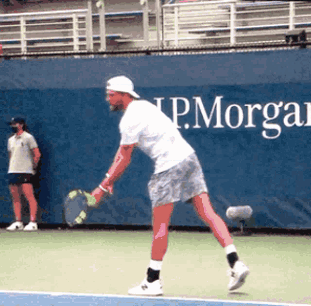 a tennis player in front of a p. morgan sign