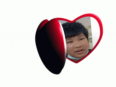 a heart shaped mirror shows a boy 's face in it