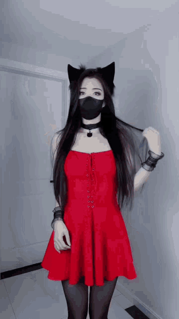 a woman wearing a black mask and a red dress