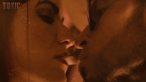a man and a woman are kissing in a room .