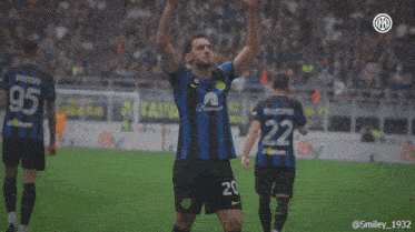 a soccer player with the number 20 on his jersey stands on the field