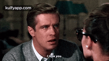 a man and a woman are looking at each other and the man is saying i love you .