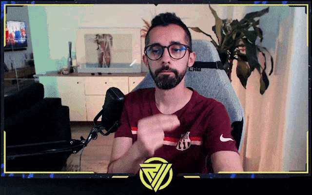 a man wearing glasses and a shirt that says nike is sitting in front of a microphone