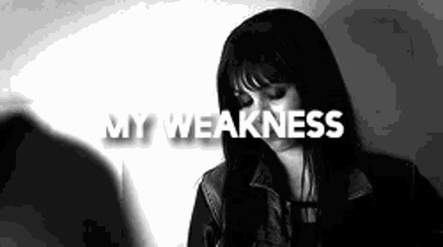 a black and white photo of a woman with long hair and the words `` my weakness '' written on her face .
