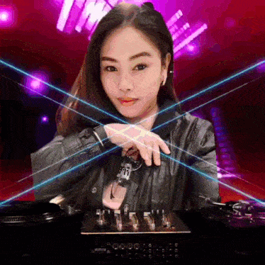 a woman in a black jacket is standing in front of a mixer with the word tm on the front
