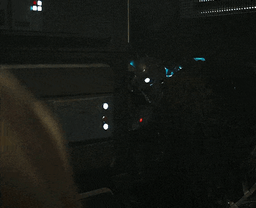 a blurred image of a person in a dark room with a few lights on