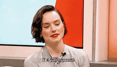 a woman is saying she 's just my peanut while sitting in front of a television .