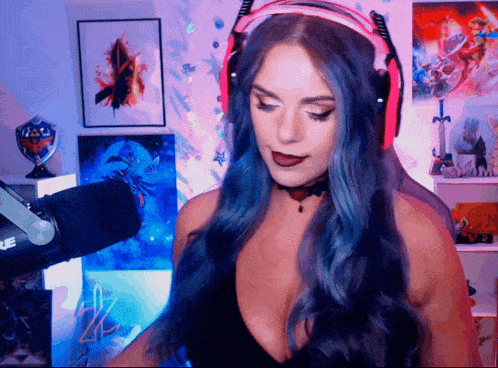 a woman wearing headphones and a choker stands in front of a microphone