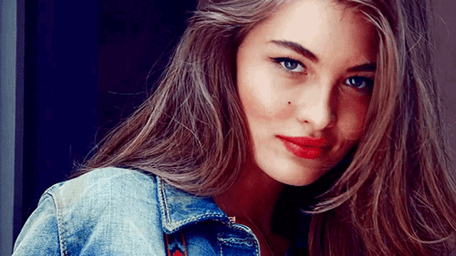 a close up of a woman wearing a denim jacket