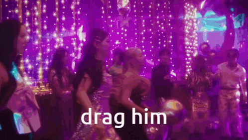 a group of people are dancing in a room with purple lights and the words `` drag him '' .