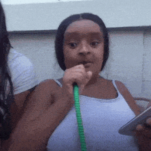 a young girl is smoking a hookah while holding a cell phone in her hand .