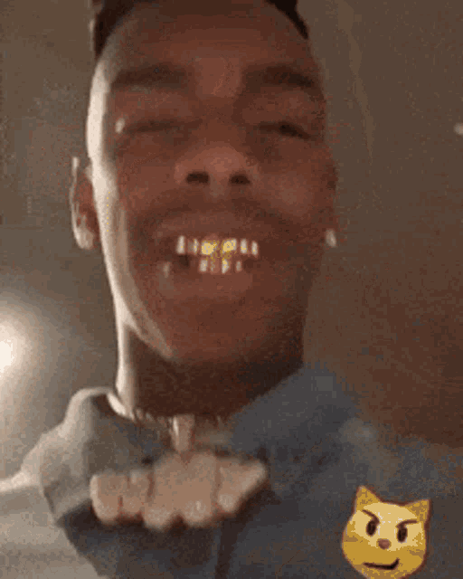 a close up of a man 's face with a yellow cat emoji on his shoulder
