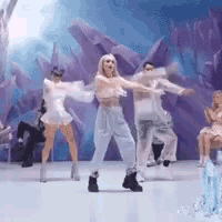 a group of people are dancing on a stage in front of a purple backdrop .