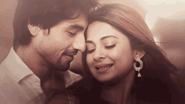 a man and a woman are looking at each other and smiling
