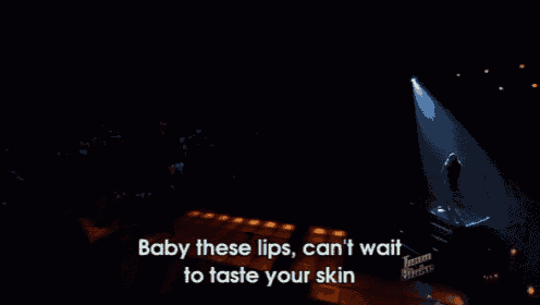 a woman singing into a microphone on a stage with the words baby these lips can 't wait to taste your skin