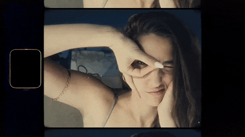 a woman making a funny face with her hands on her eyes
