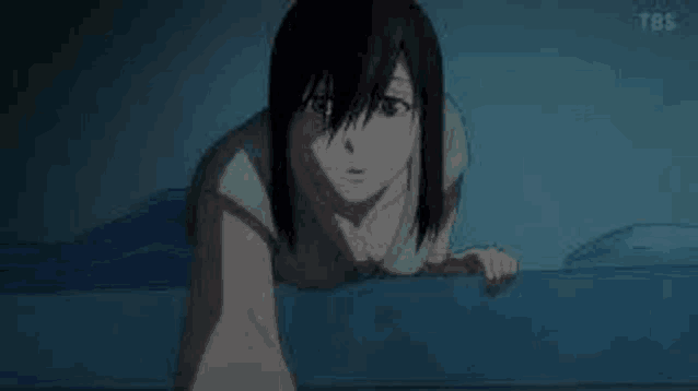 a woman is crawling on top of a blue bed .