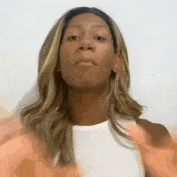 a woman with long hair is wearing a white shirt and making a funny face .