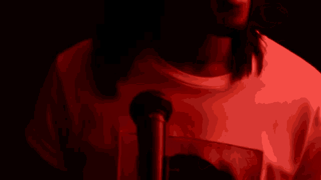 a man with long hair is singing into a microphone