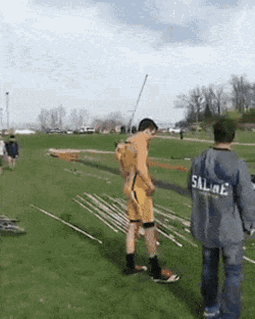 a man in a shirt that says sal-me is standing in a field