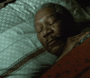 a man with a beard is sleeping in a bed