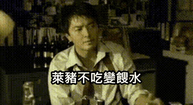 a man in a white shirt and tie is sitting at a table with chinese writing on it