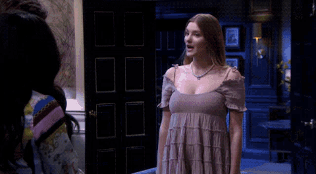 a woman in a purple dress is talking to another woman