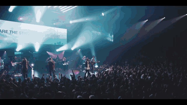 a group of people singing in front of a sign that says " are the stars of my heart "