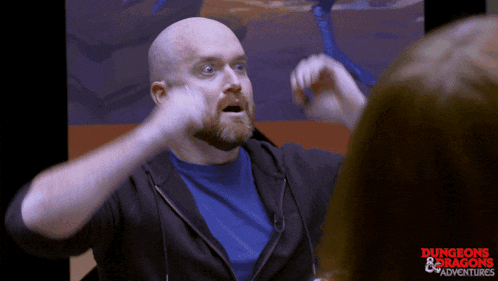 a bald man with a beard is wearing a blue shirt that says dungeons & dragons