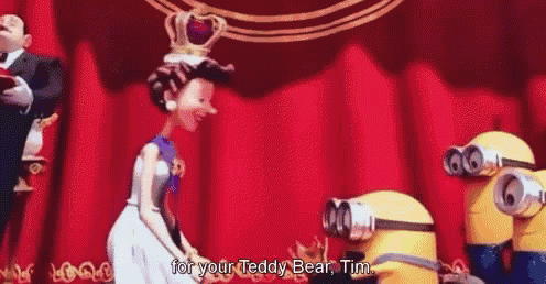 a woman with a crown on her head is standing in front of a red curtain talking to a group of minions .