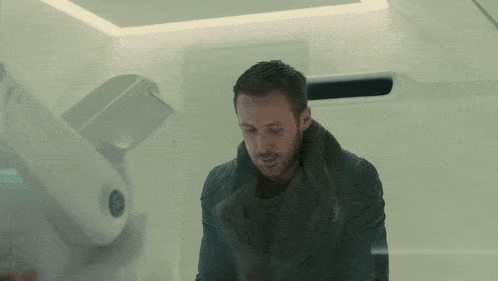 a man in a fur coat is standing in front of a white wall