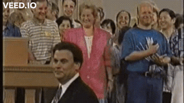 a man in a suit and tie is standing in front of a crowd of people with the words " veed.io " on the bottom